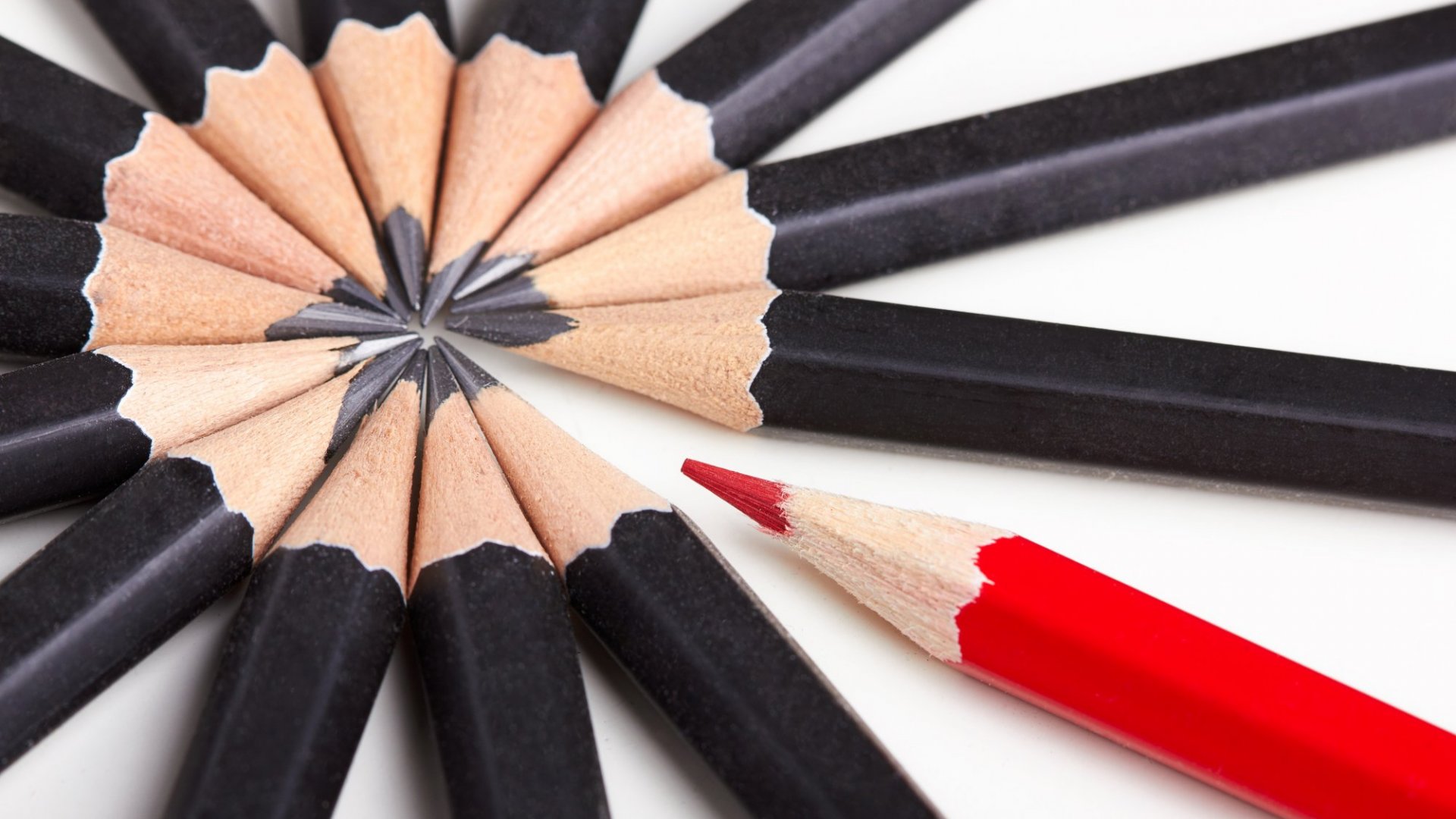 A circle of black pencils and one red pencil